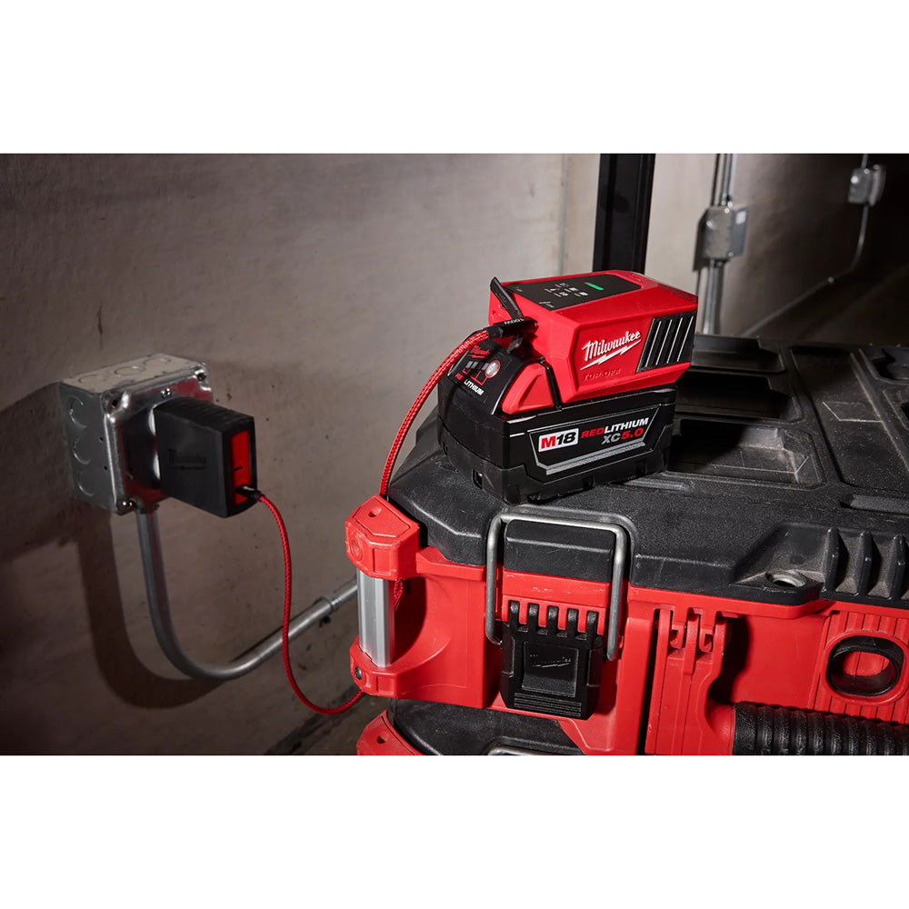 Red Milwaukee power tool with battery pack on a concrete surface