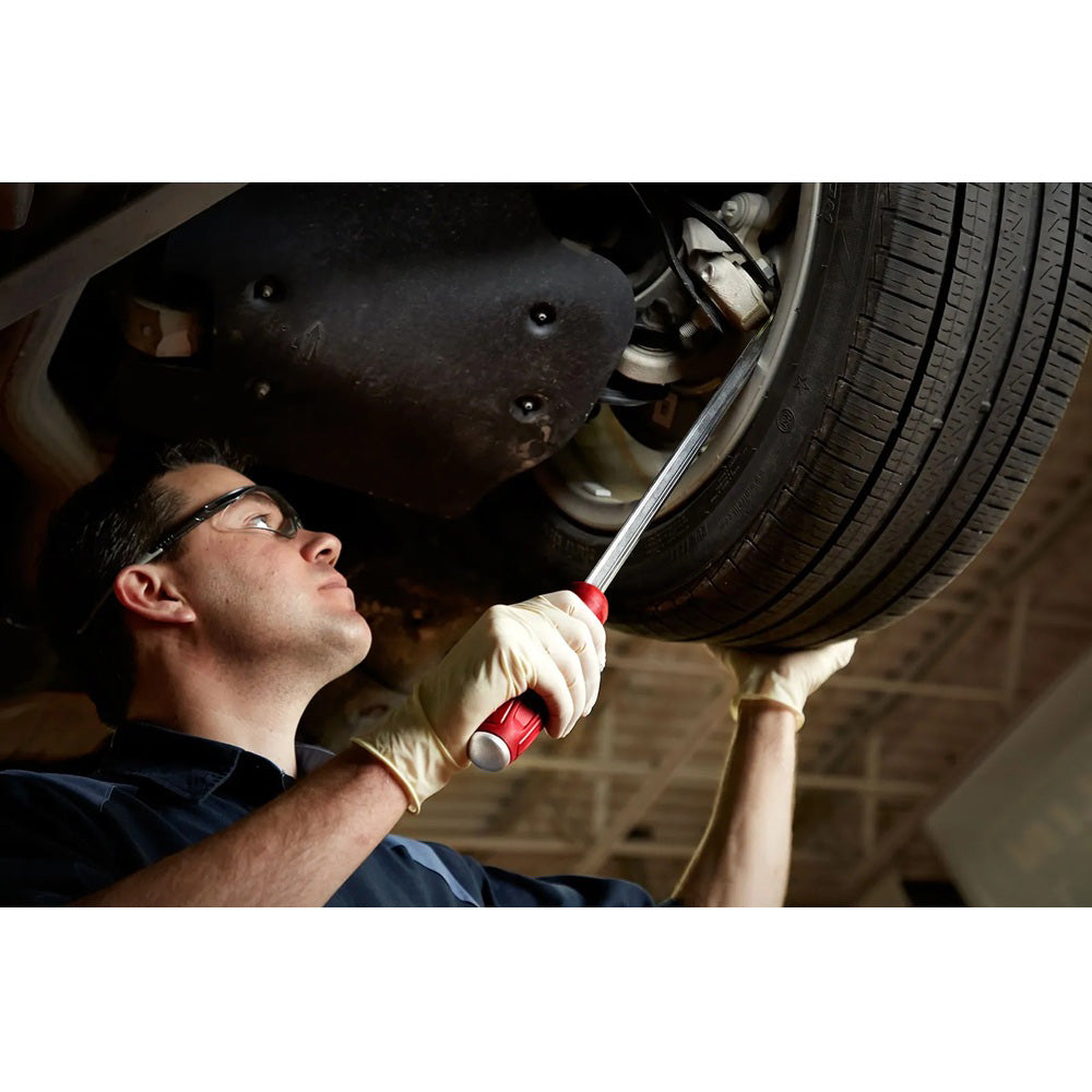 Mechanic working on a car tire under a vehicle