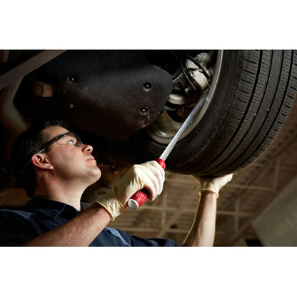 Mechanic working on a car tire under a vehicle
