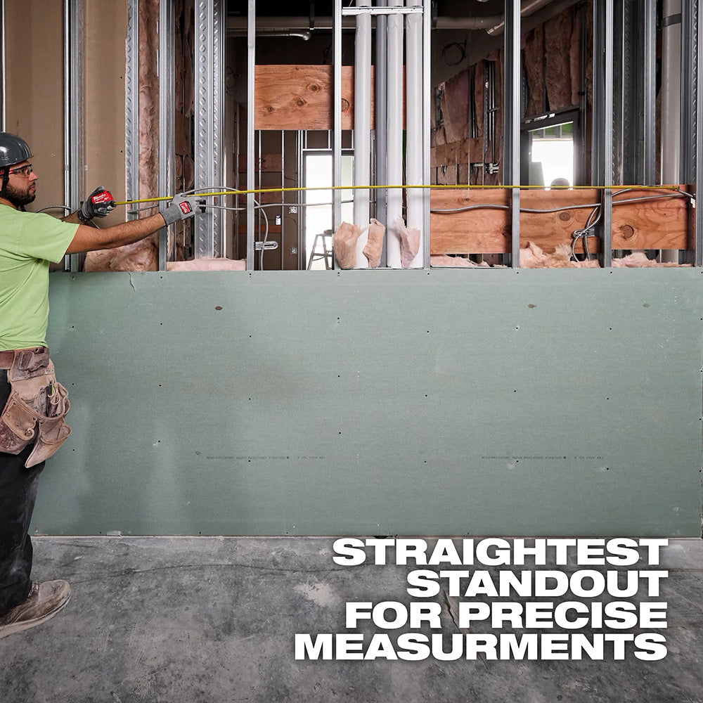 Person using a tape measure on a wall with construction materials in the background