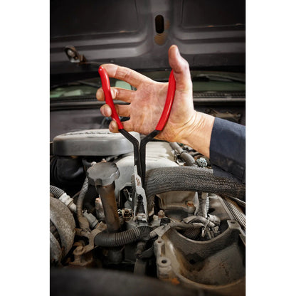 Hand using red pliers on a car engine