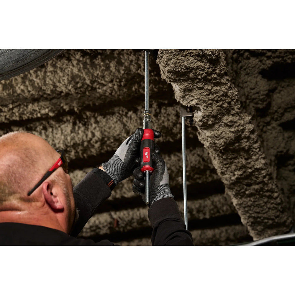 Person using a tool to inspect or repair an underground pipe system.