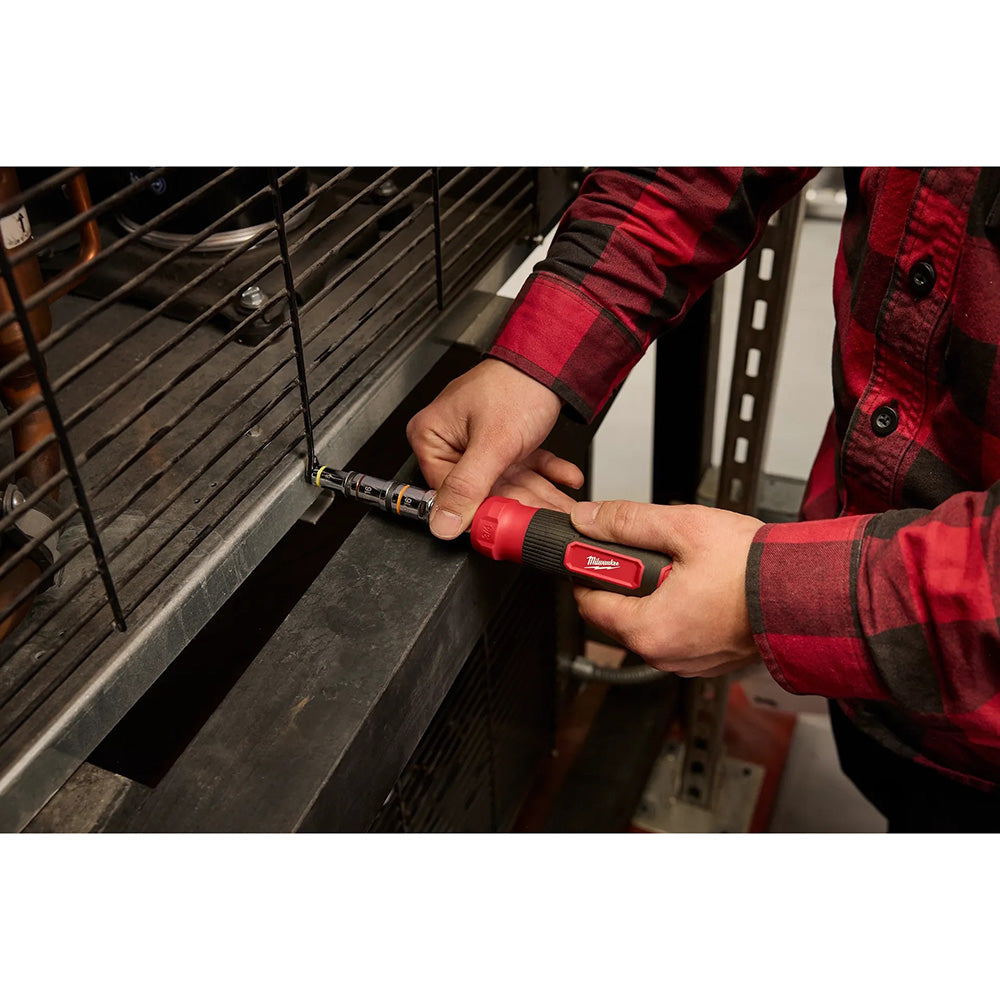 Person using a Milwaukee tool on an oven door