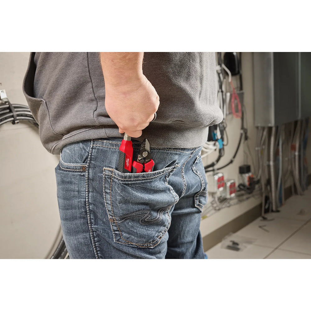 Person wearing a tool belt with pliers in a workshop setting
