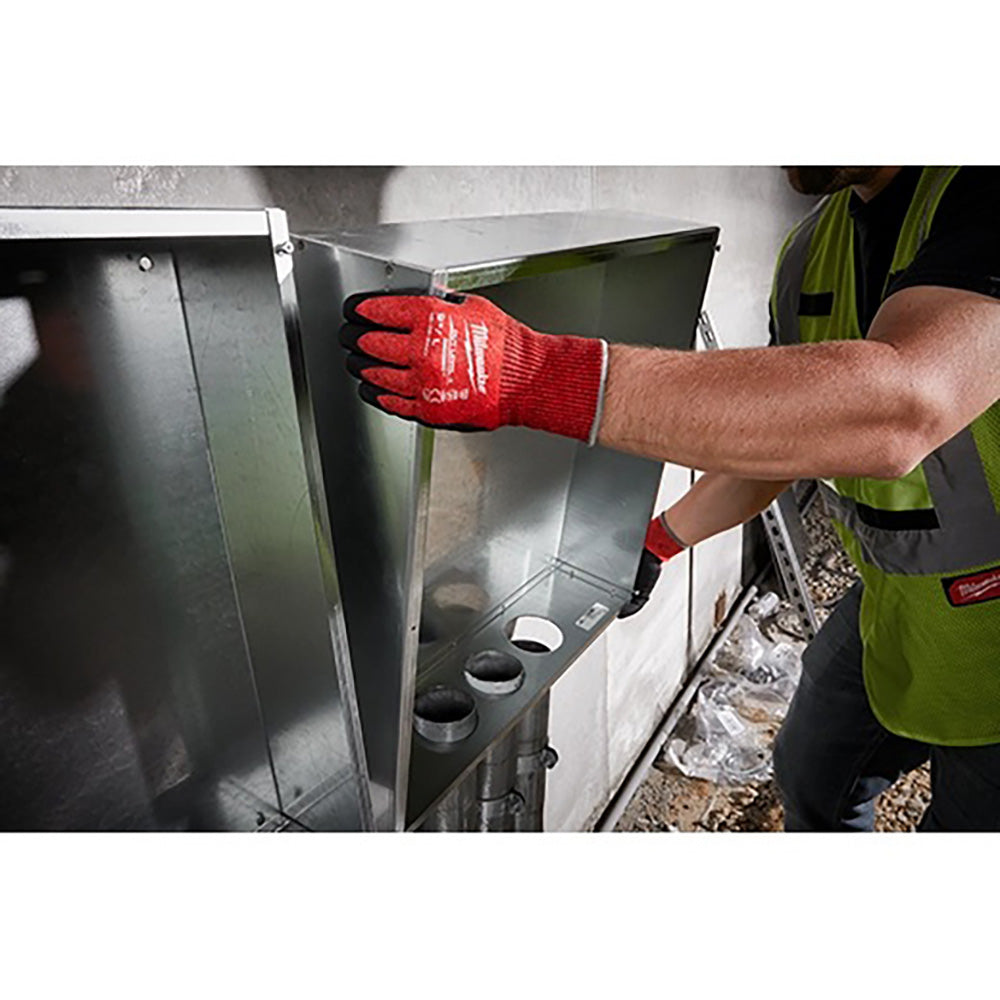 Person wearing a red glove and green safety vest working.