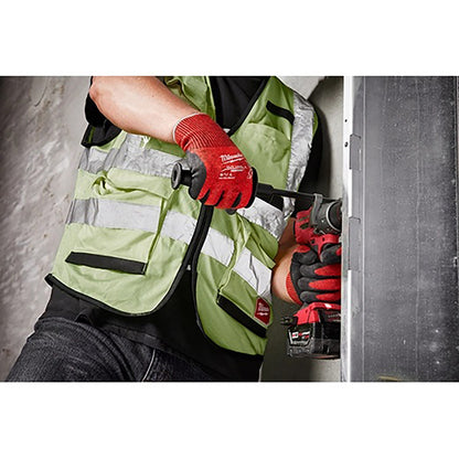 Person wearing a green safety vest and red gloves using a power tool.