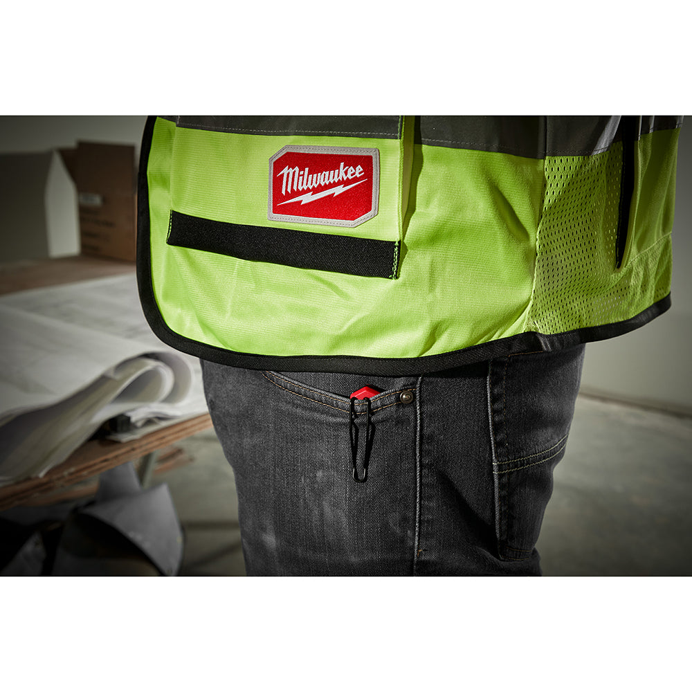 Person wearing a high-visibility green apron with a logo patch.