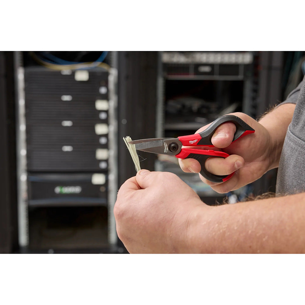 Person using a red and black tool in a workshop setting