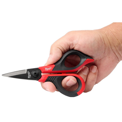 Hand holding a pair of Milwaukee scissors with red and black handles on a white background