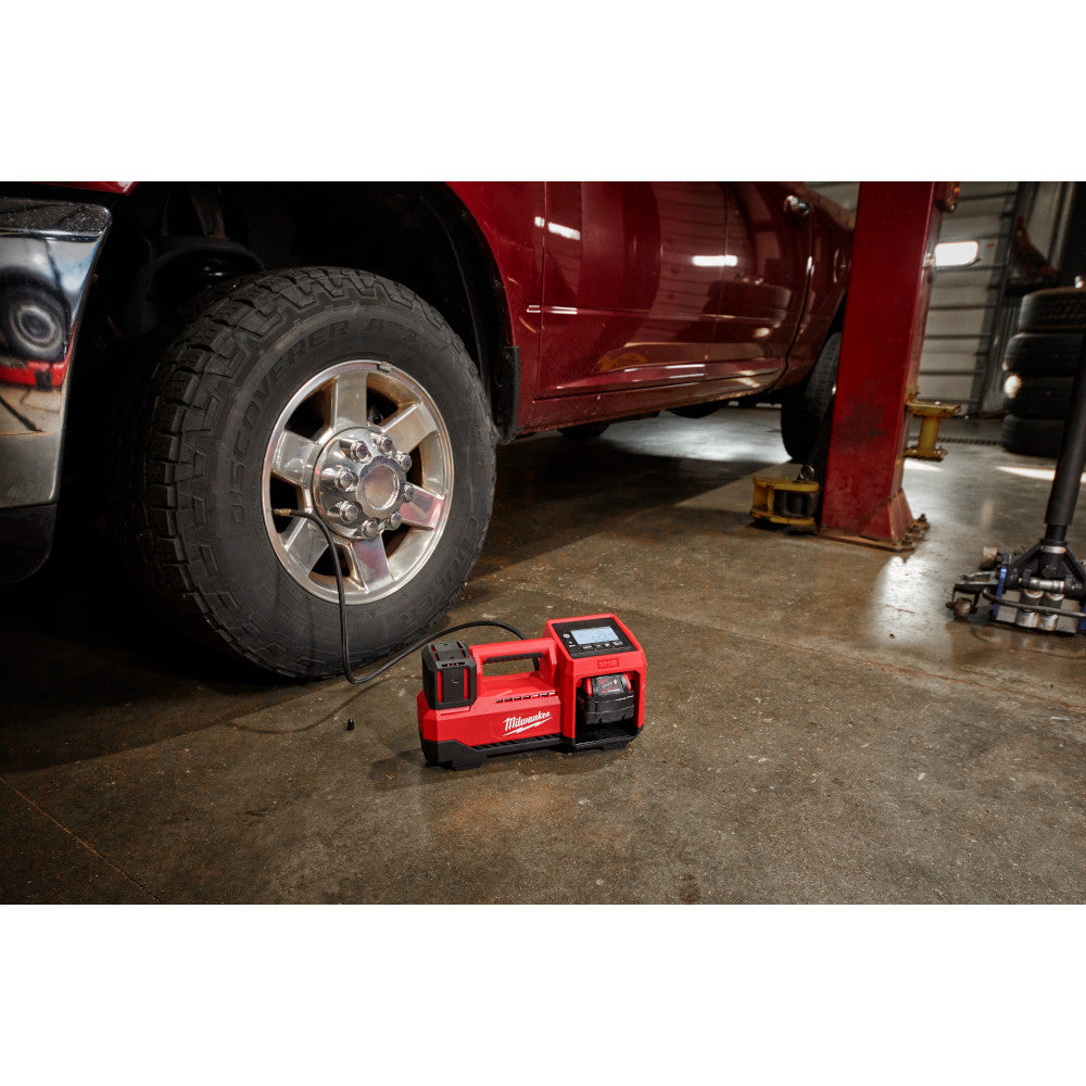M18™ Inflator on a garage floor with a vehicle in the background.