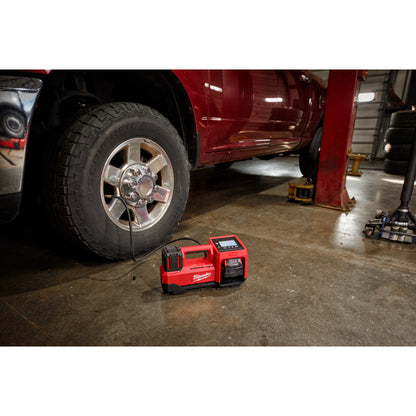 M18™ Inflator on a garage floor with a vehicle in the background.