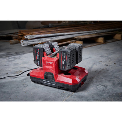 Milwaukee battery charger with four batteries on a concrete floor.