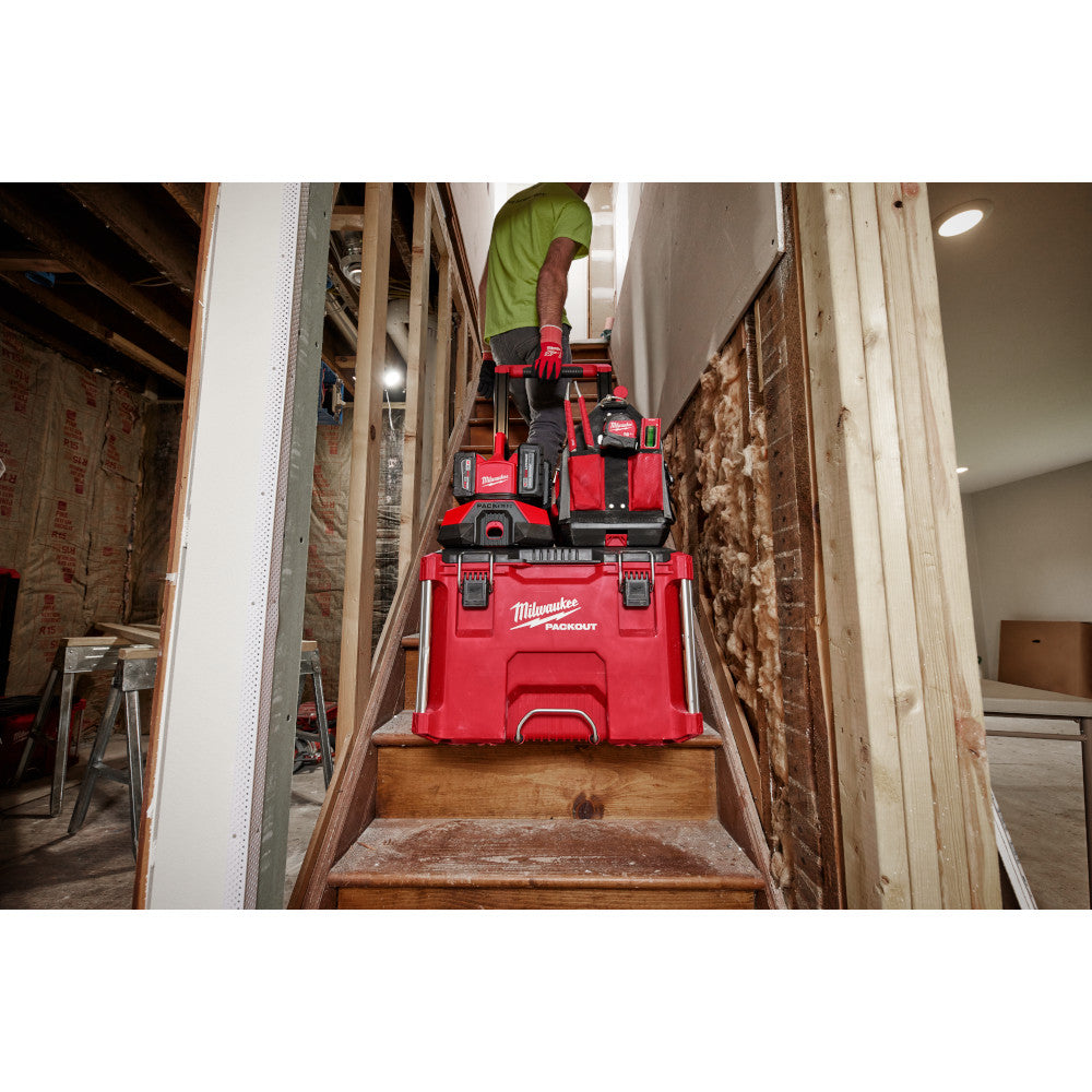 M18™ PACKOUT™ Six Bay Rapid Charger with PACKOUT™ Cart and toolboxes on a staircase in a workshop.