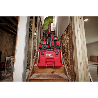 M18™ PACKOUT™ Six Bay Rapid Charger with PACKOUT™ Cart and toolboxes on a staircase in a workshop.