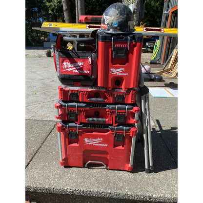 Stack of red PACKOUT boxes with a on a concrete surface.