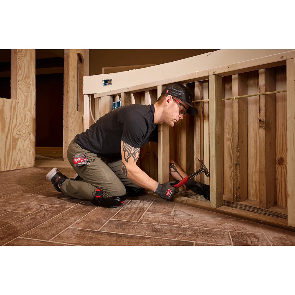Person working on a wooden structure using a hammer.